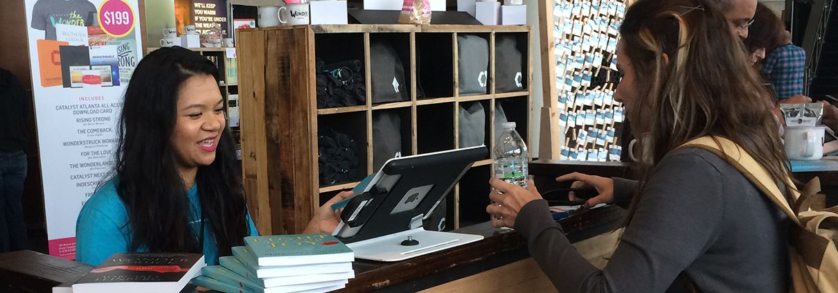 A person sitting at a table with a laptop and water bottle.