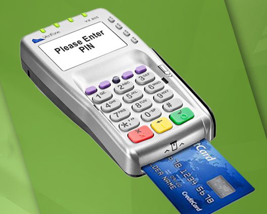 A credit card machine is shown with the chip on its side.